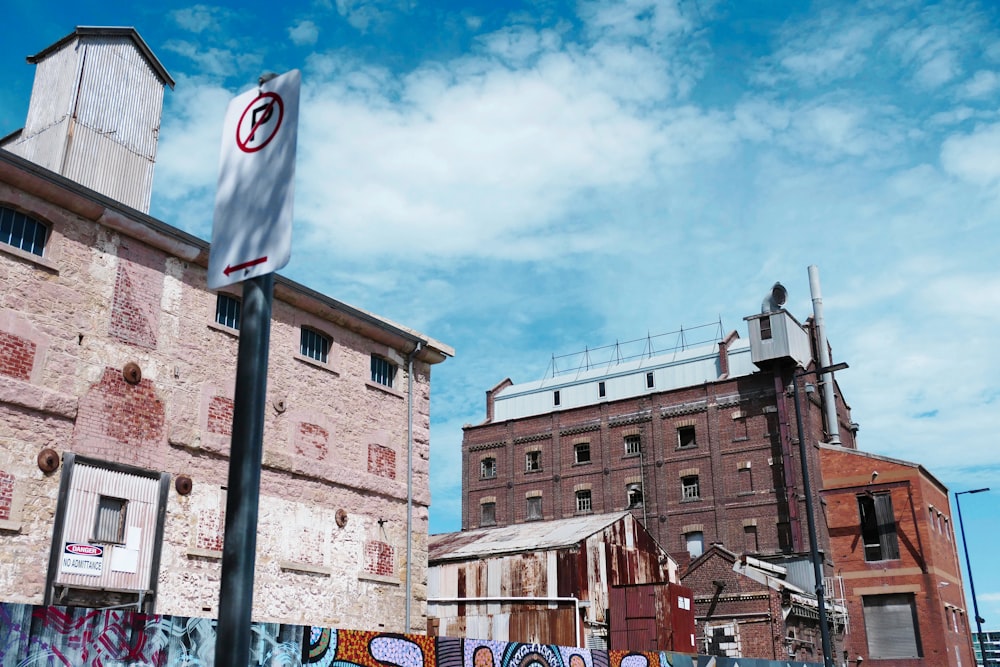 a street sign in front of a building with graffiti on it