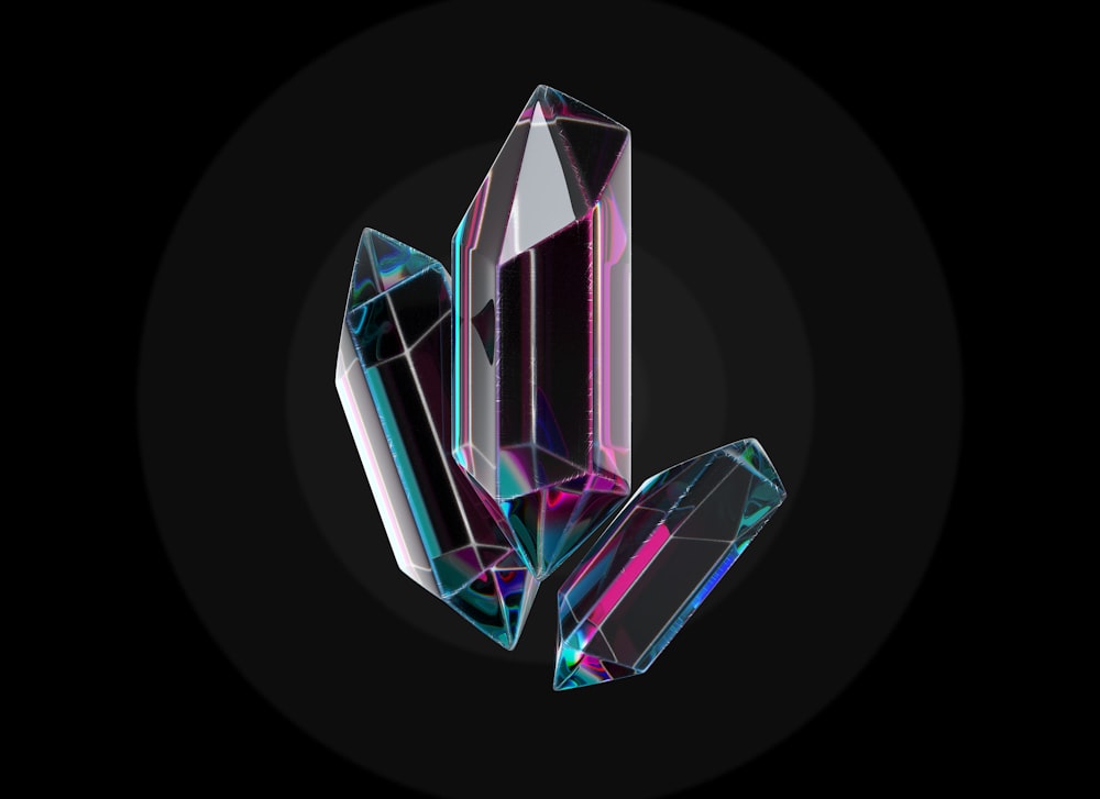 three different colored crystals on a black background