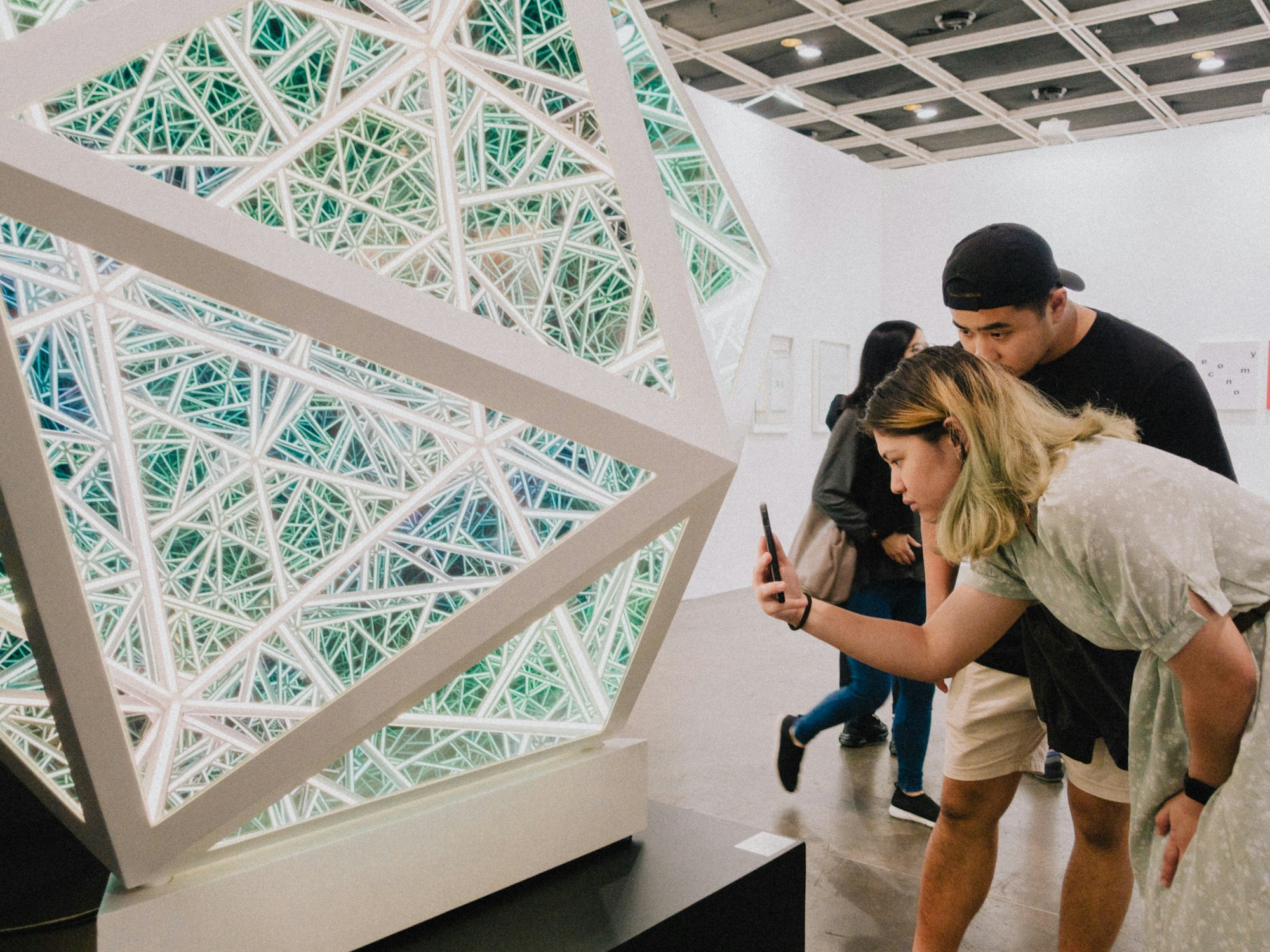 a man and a woman looking at a cell phone to explore interactive exhibit