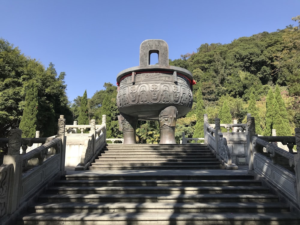 a staircase leading up to a statue in the middle of a park