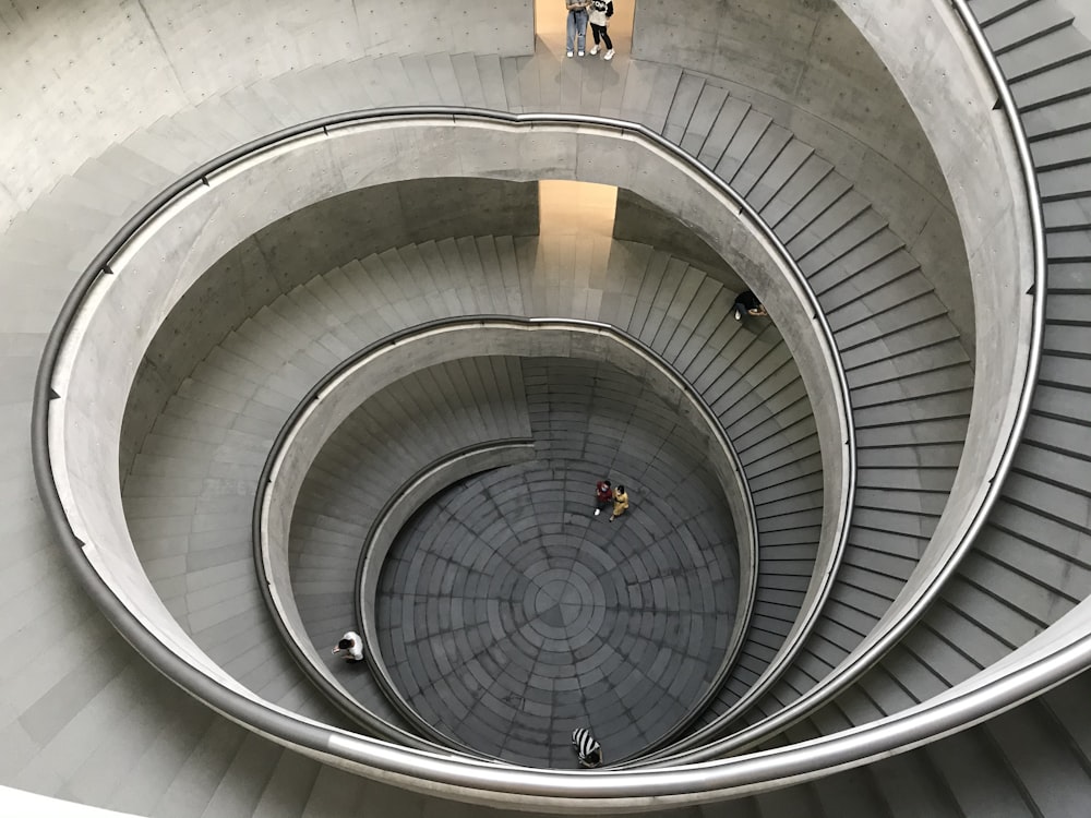 a group of people walking up and down a spiral staircase