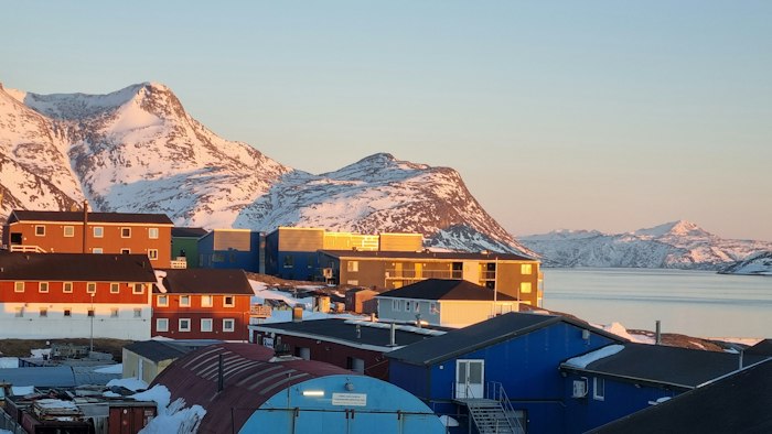Small Greenlandic town with mountains — where AimerWorld members live