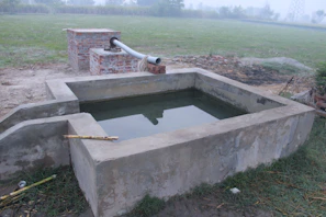 Technician inspecting waterproofing seal on a concrete water tank at a construction site