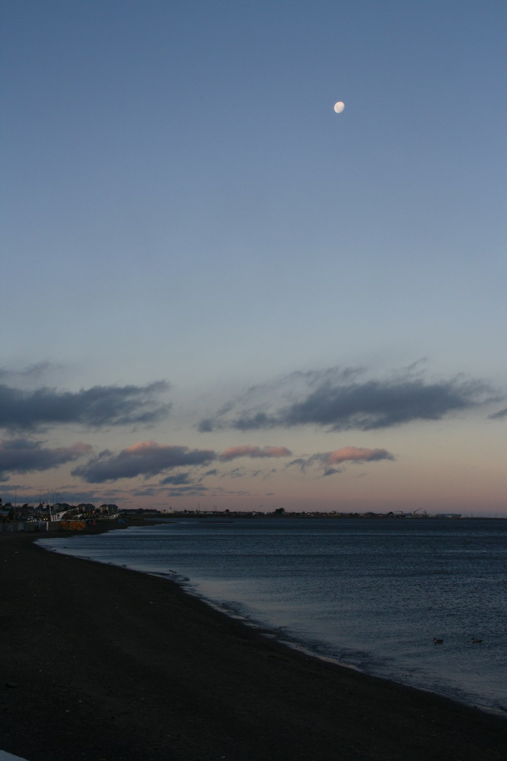 a full moon is seen over the ocean