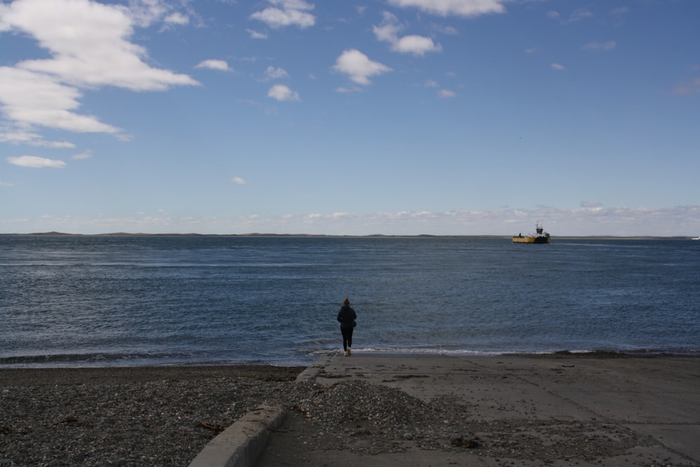 a person standing on a beach next to the ocean