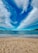 A scenic view of Pensacola Beach with soft white sand and clear blue waters under a bright sky.