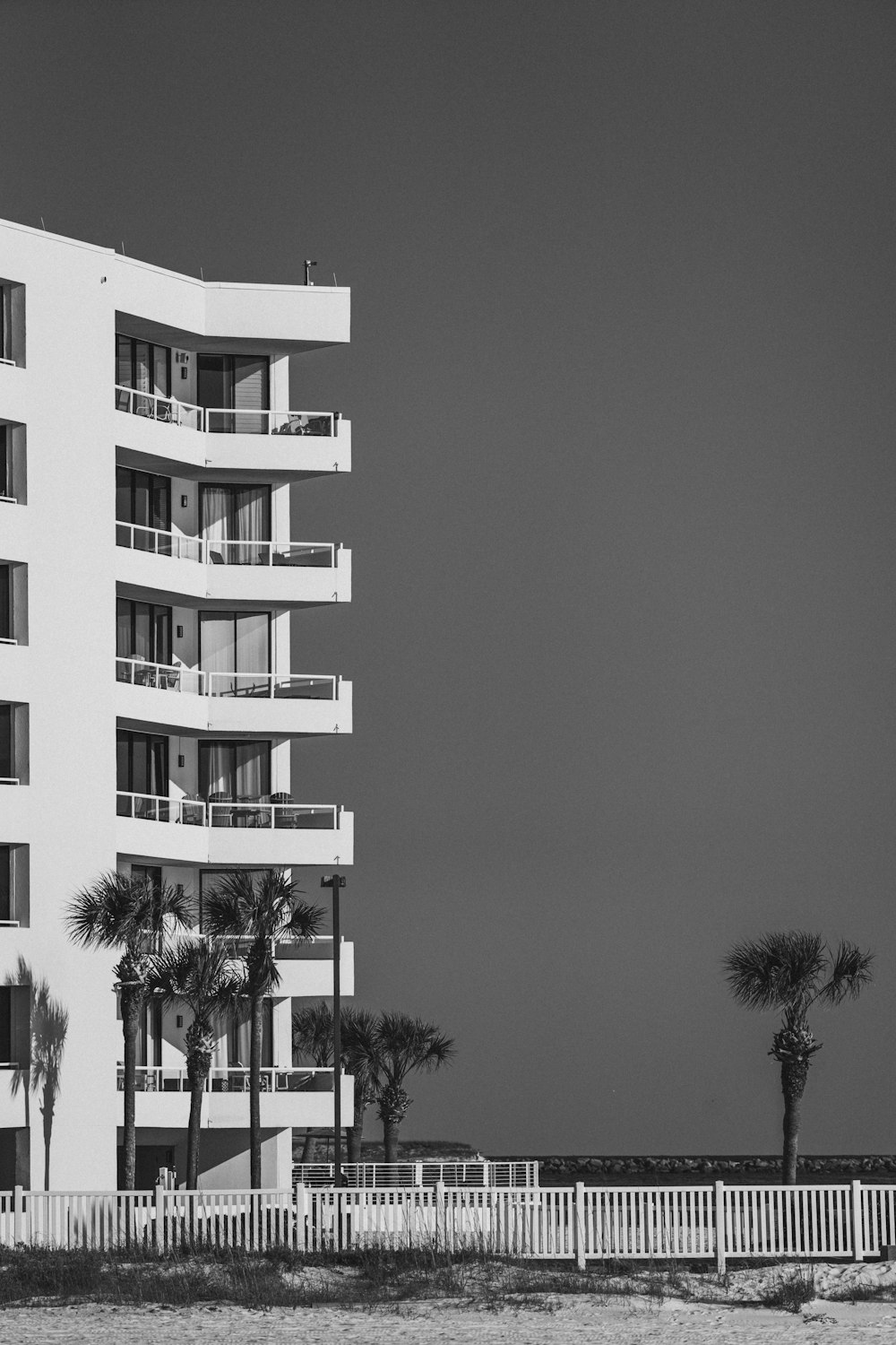 a tall white building sitting next to a beach