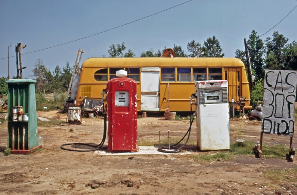 um antigo posto de gasolina com um ônibus amarelo no fundo