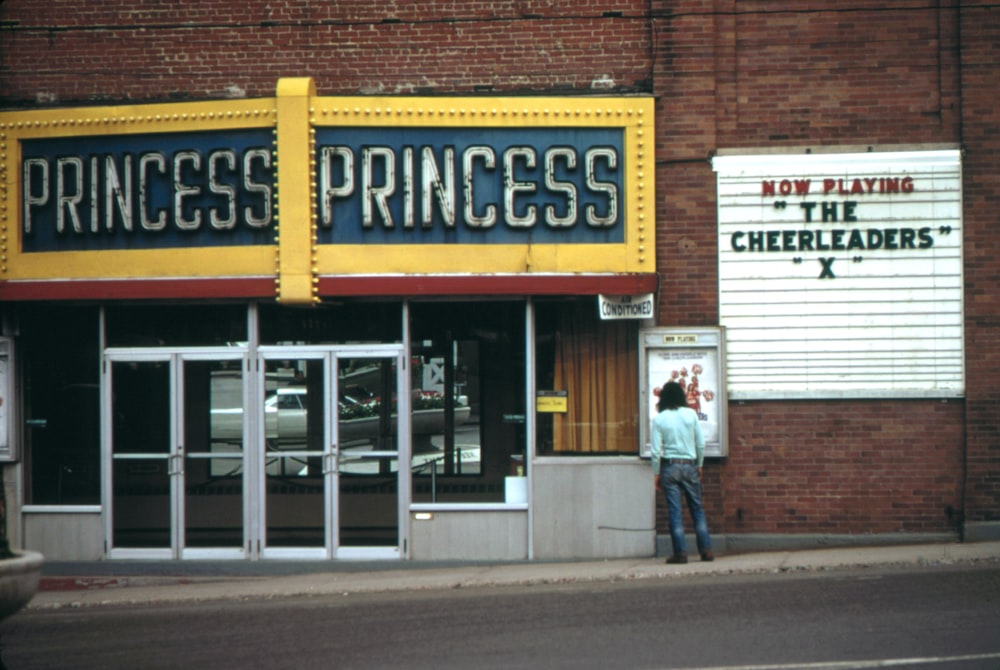 Un homme debout devant un magasin de princesses