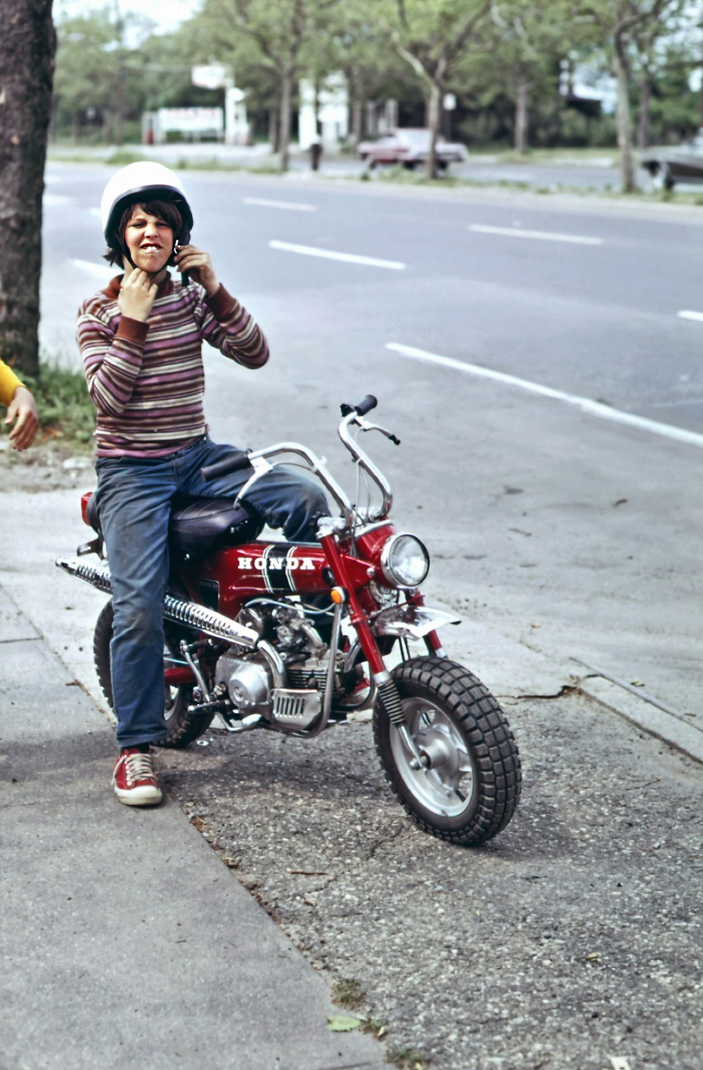 um homem sentado em uma motocicleta falando em um telefone celular