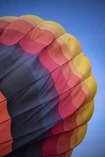 Close-up of a luxurious balloon basket edge adorned with royal gold accents against clear blue sky.