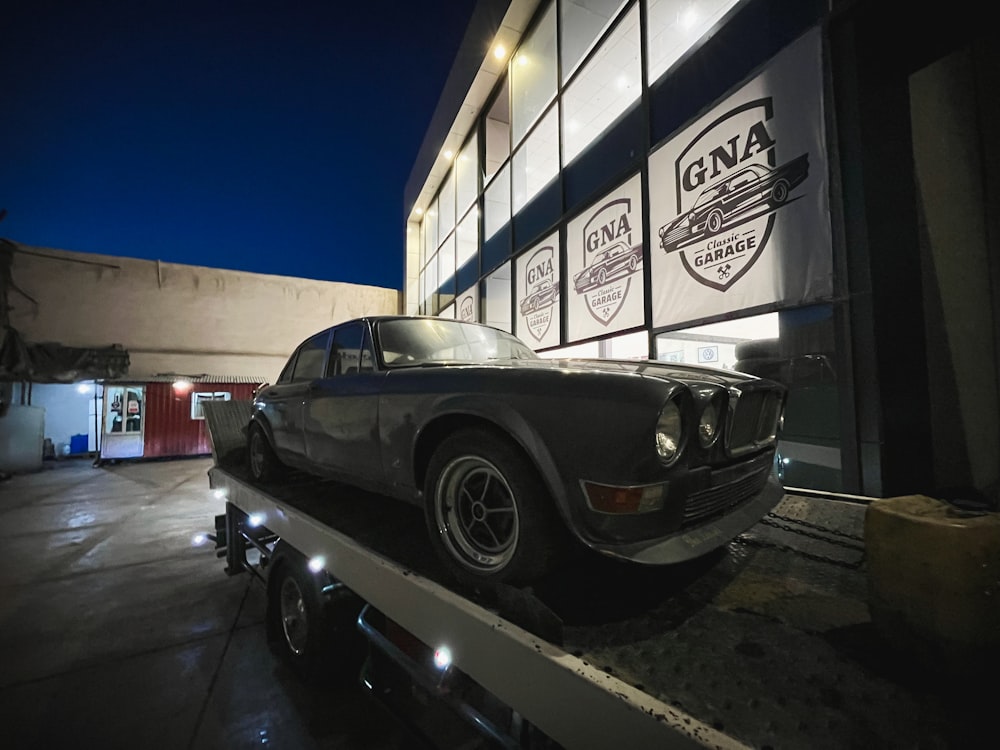 a car on a flatbed in front of a building