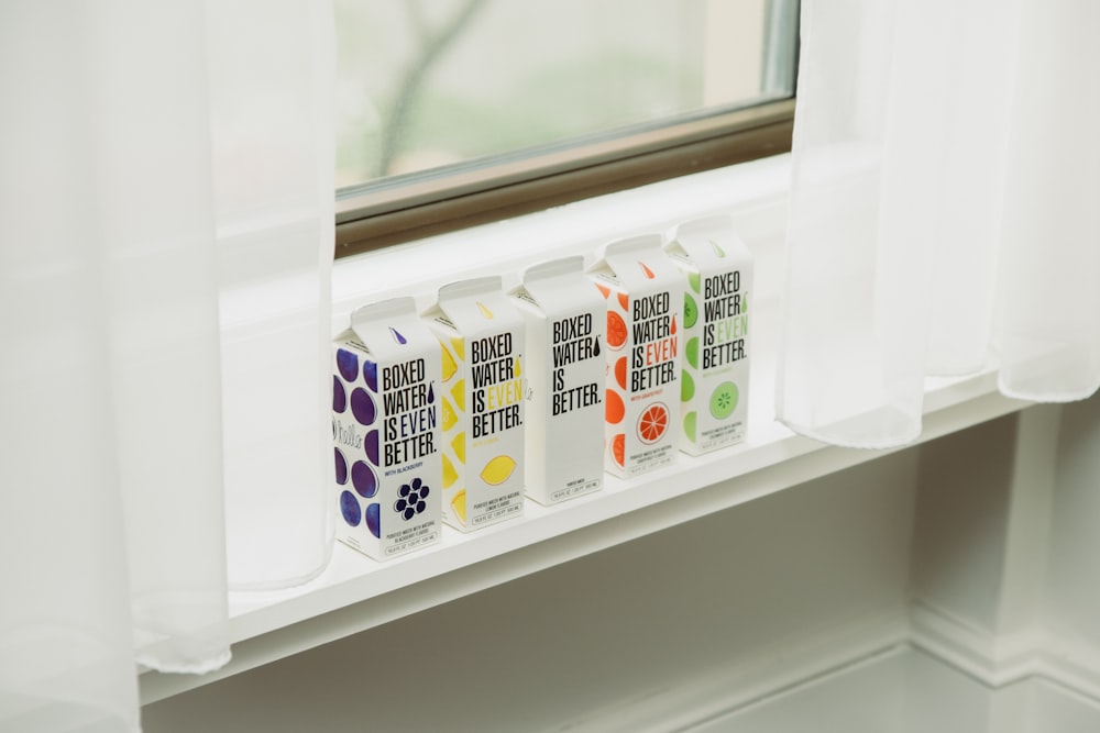 a window sill with three juice cartons in front of it