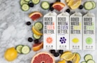 three boxes of boxed water are surrounded by sliced fruit