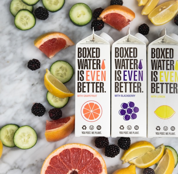 three boxes of boxed water are surrounded by sliced fruit