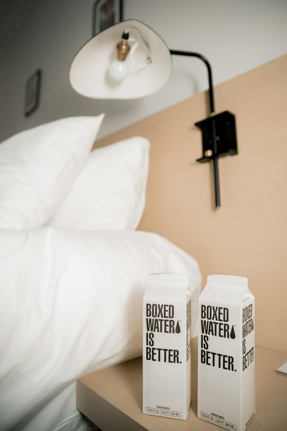 two boxes of boxed water sitting on a bed