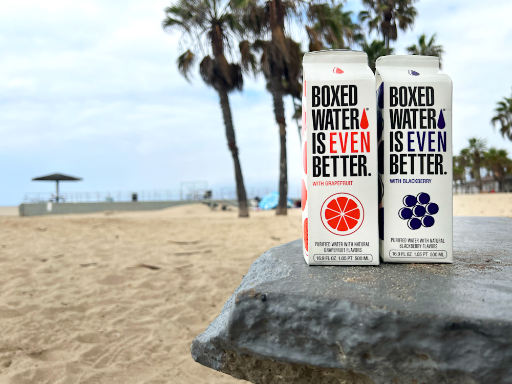 two boxes of boxed water are sitting on a rock