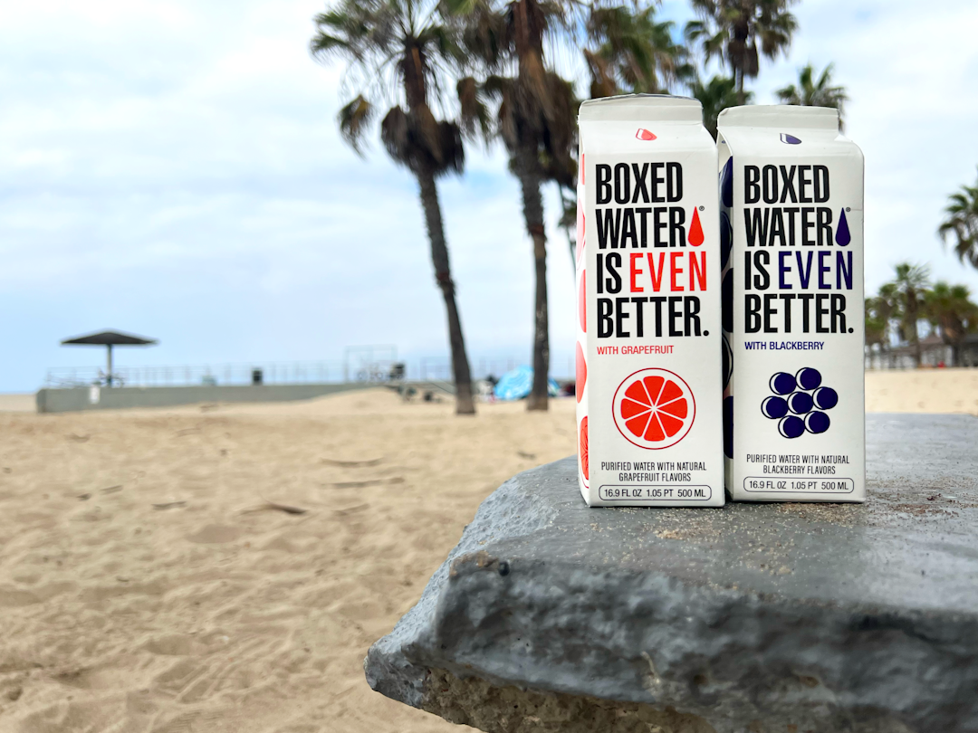 two boxes of boxed water are sitting on a rock,