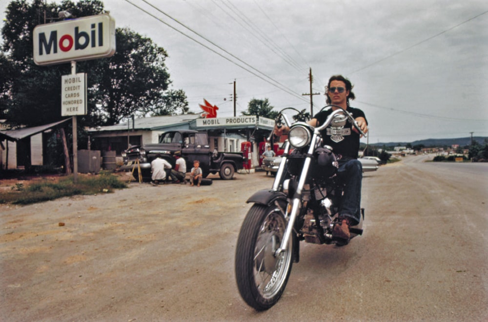 Ein Mann fährt mit dem Motorrad eine unbefestigte Straße hinunter