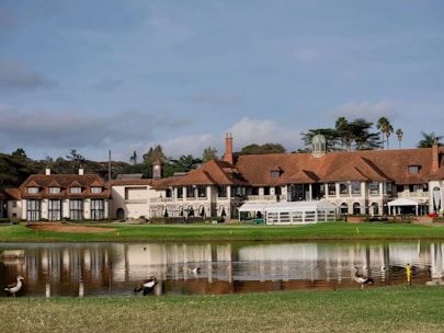 a large mansion with a lake in front of it