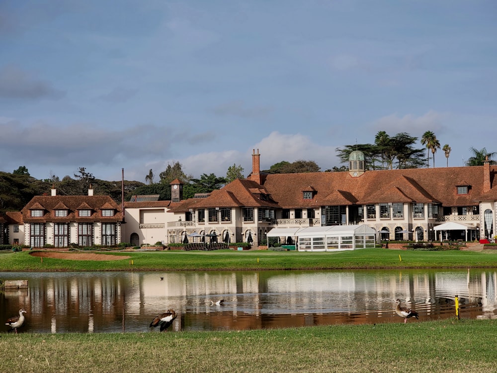 a large mansion with a lake in front of it