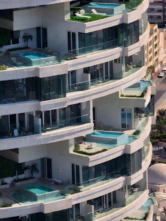 a very tall building with balconies and a swimming pool