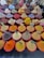 An array of colorful spices and herbs displayed in large red-lipped bowls. Each bowl contains a different spice, with labels such as paprika, nutmeg, cumin, and ginger. The spices are neatly arranged, creating a vibrant and diverse tapestry of textures and colors.