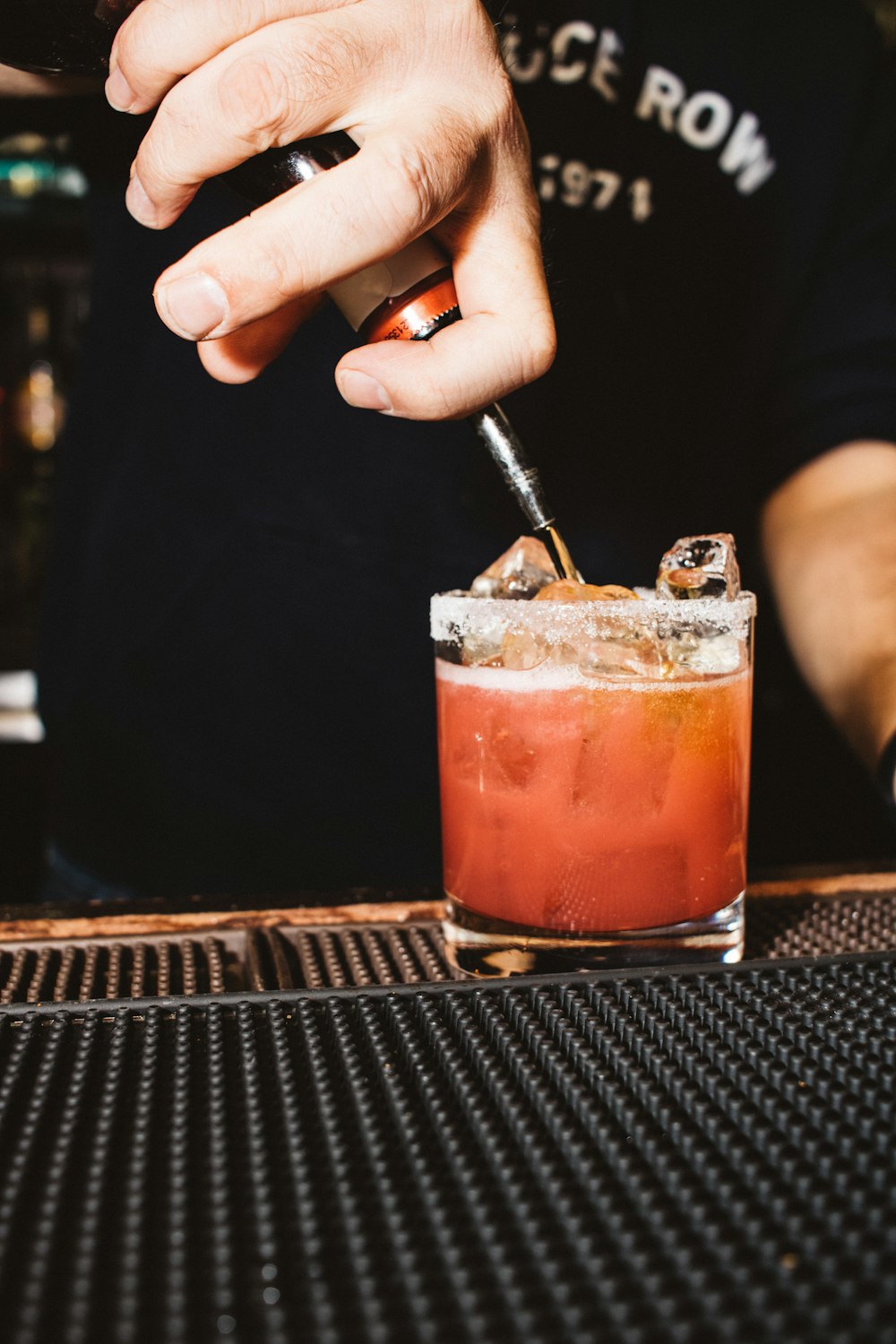 a man is making a drink at a bar