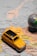 A small, vintage yellow toy car is placed on a map of Europe, highlighting cities in countries like Italy, France, and Switzerland. A small globe is partially visible on the right, emphasizing travel and exploration themes.