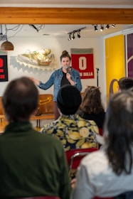 Comedian performing on stage with microphone and audience laughing.