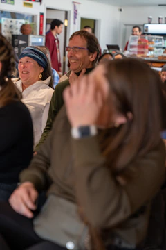 A mentor and mentee sharing a laugh over coffee in a cozy community center.