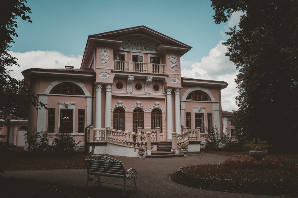 a large pink house with a staircase leading up to it