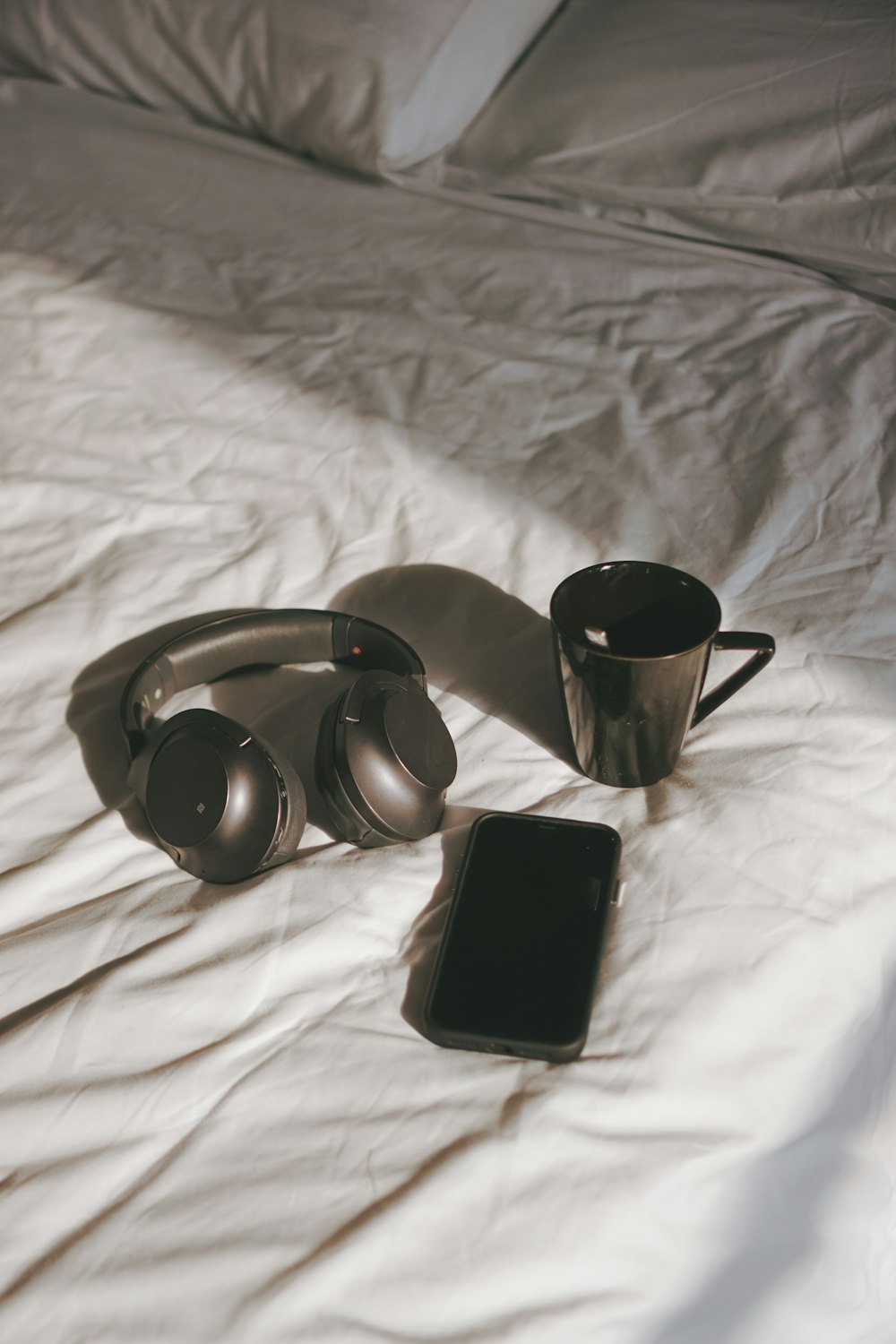 a pair of headphones and a tablet on a bed