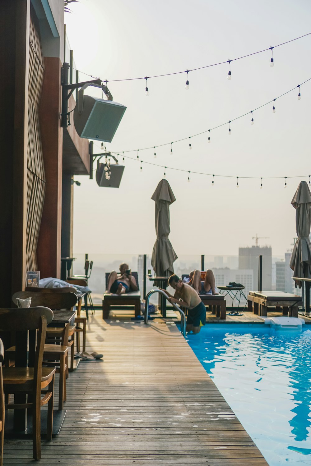 a group of people sitting around a swimming pool