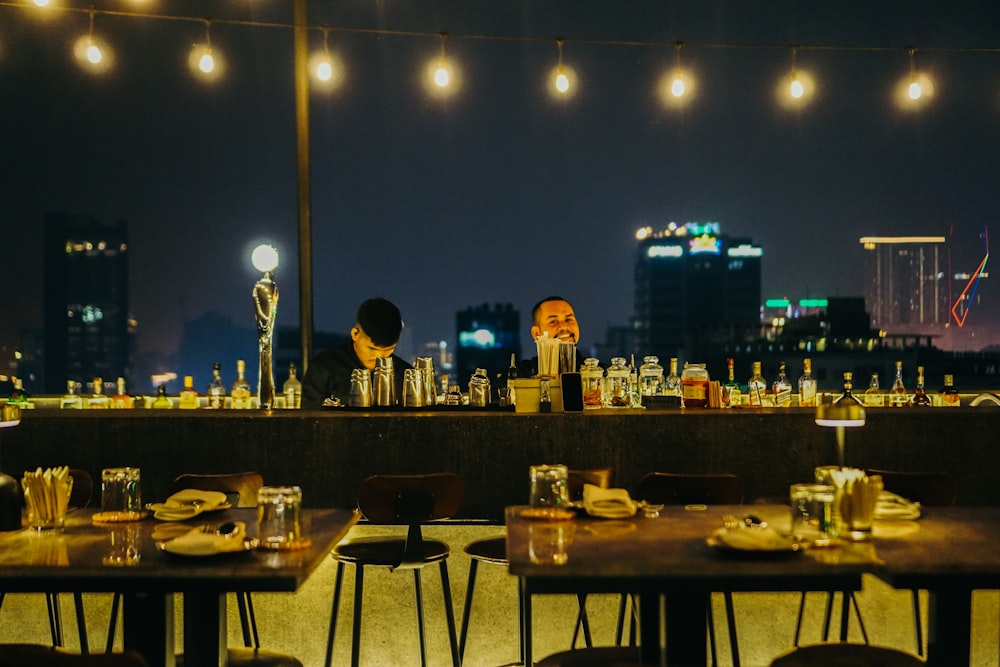 a couple of people sitting at a table in front of a bar