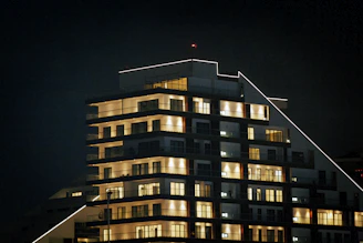Night view of a well-lit urban building highlighting its geometric shapes