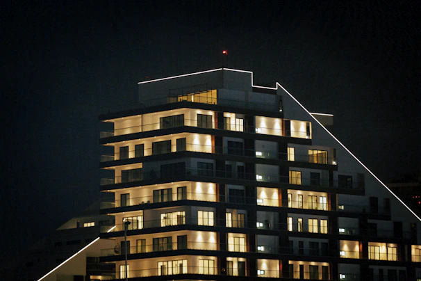 Night view of a well-lit urban building highlighting its geometric shapes