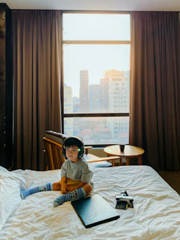 A joyful child listening to personalized music with headphones in a cozy room.