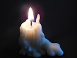 A candle burning evenly with melted wax spread across the surface.