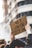A cardboard sign with French text is held up by a person in an urban setting. The sign reads '49.3 ON EN VEUT PAS,' implying a protest or demonstration. The background shows blurred buildings, and the atmosphere suggests a gathering or march.