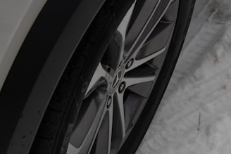 Close-up of a winter tire tread with snow in the background