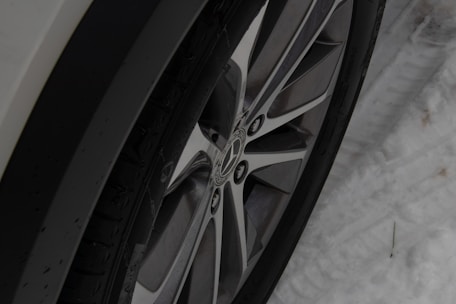 Close-up of winter tires being swapped for summer tires on a vehicle parked outside a home.