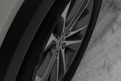 Winter tire gripping icy pavement with snowflakes around