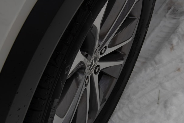 Close-up of a winter tire tread with snow in the background
