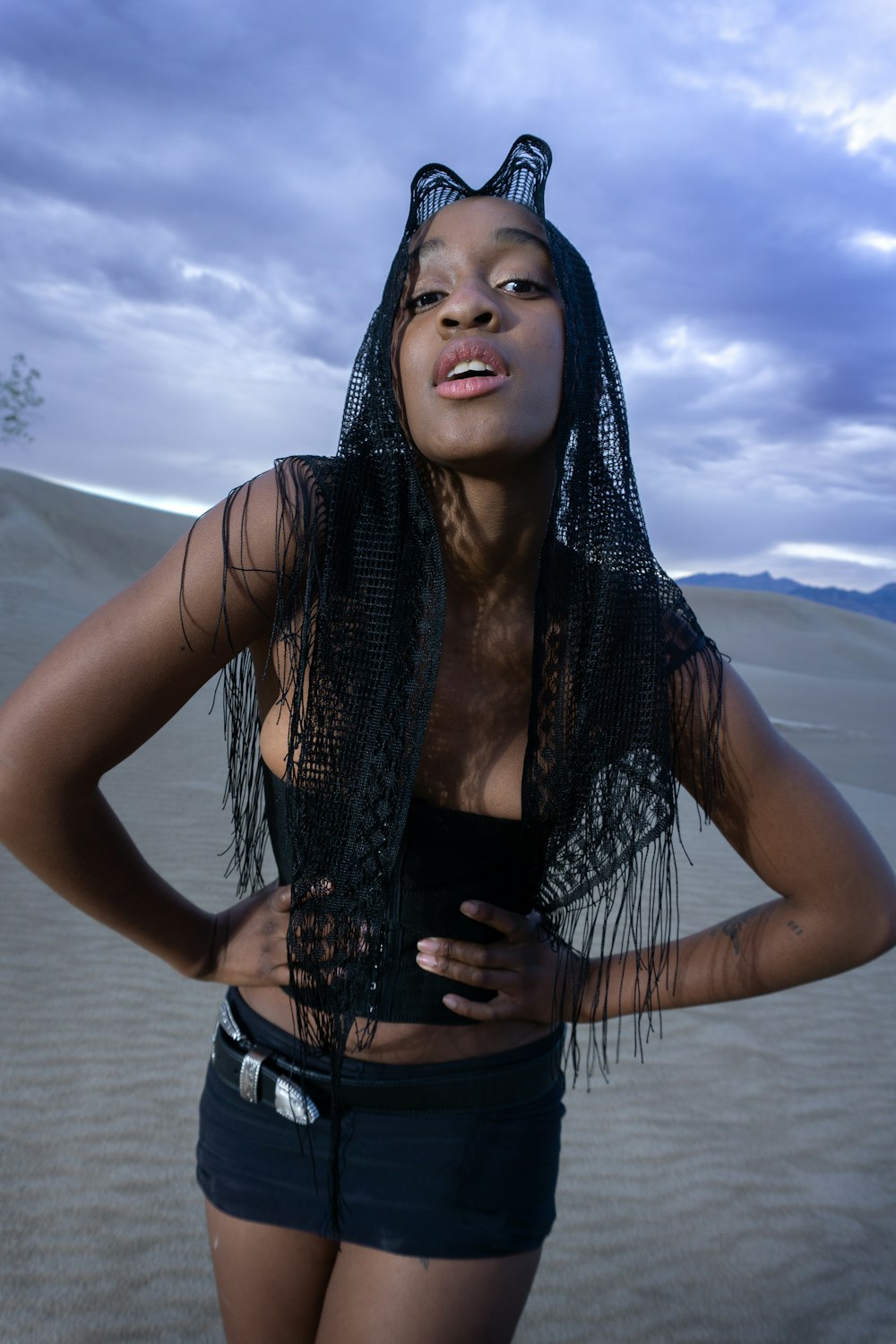 a woman in a black top and a black scarf