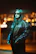 A man confidently posing in a RA Styles jacket with city lights behind him at dusk.