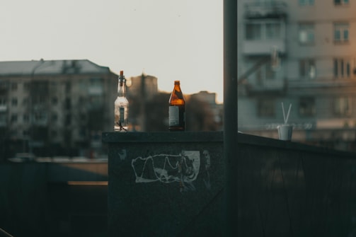 A set of minimalist glassware arranged on a concrete countertop with a blurred cityscape background.
