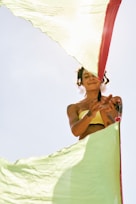 a woman in a yellow bikini holding a red and white umbrella