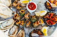 A platter of oysters on ice with lemon wedges
