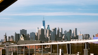 Modern city skyline blending local and international landmarks under a deep blue sky.